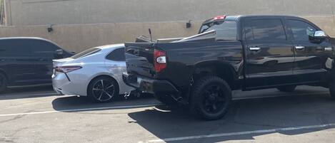 A black pickup truck parked in a lot with a white car beside it.