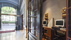 Un intérieur moderne comprenant un comptoir d’accueil, deux postes informatiques et une radio ancienne.