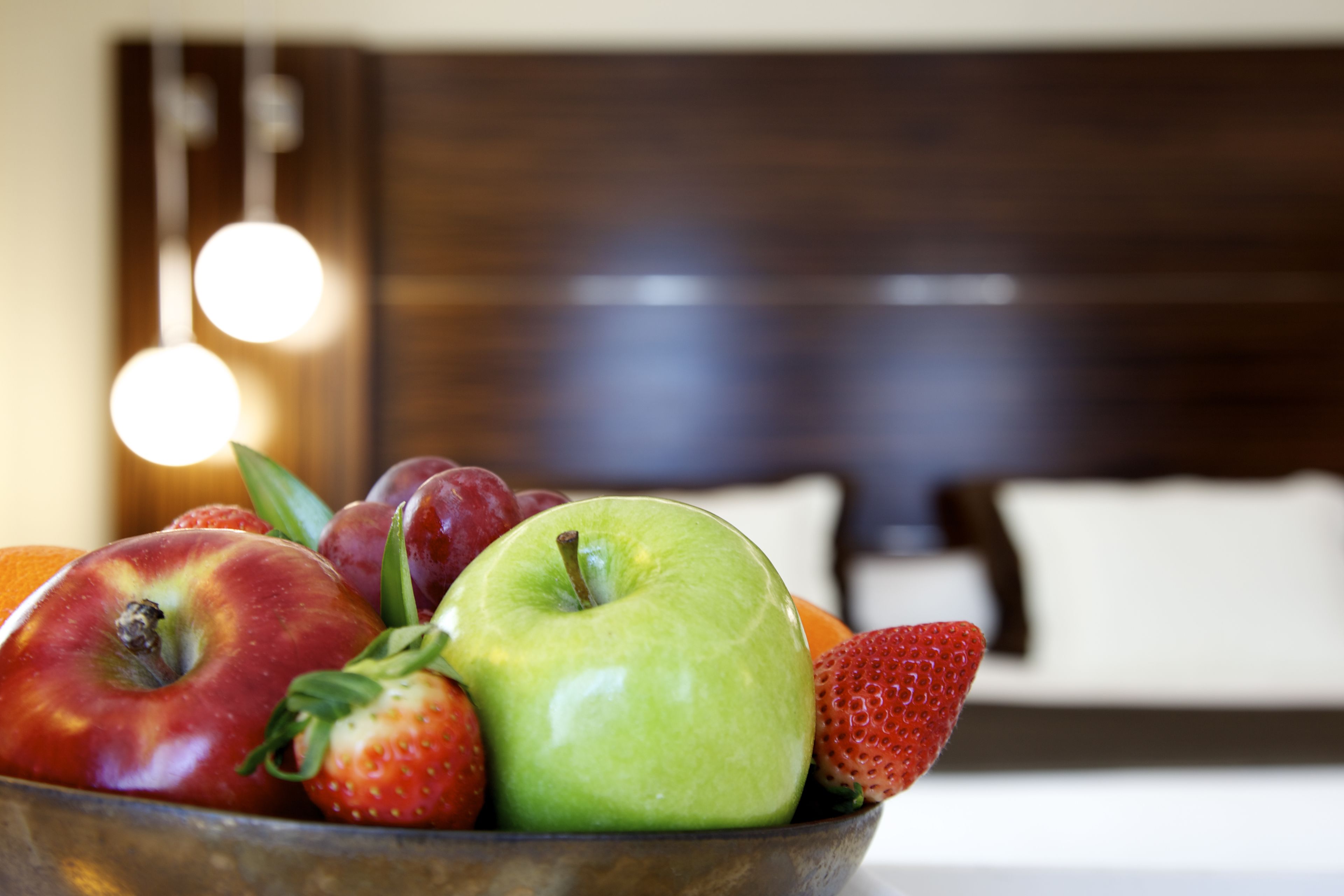 Un tazón de fruta con manzanas, fresas y naranjas.