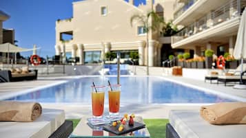 Een binnenzwembad, 2 buitenzwembaden en parasols bij het zwembad