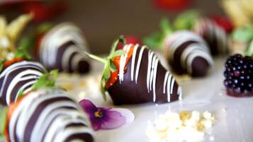 Des fraises enrobées de chocolat, nappées de glaçage blanc, présentées sur une assiette.