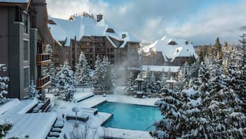 Una località turistica con piscina circondata da alberi e edifici innevati.