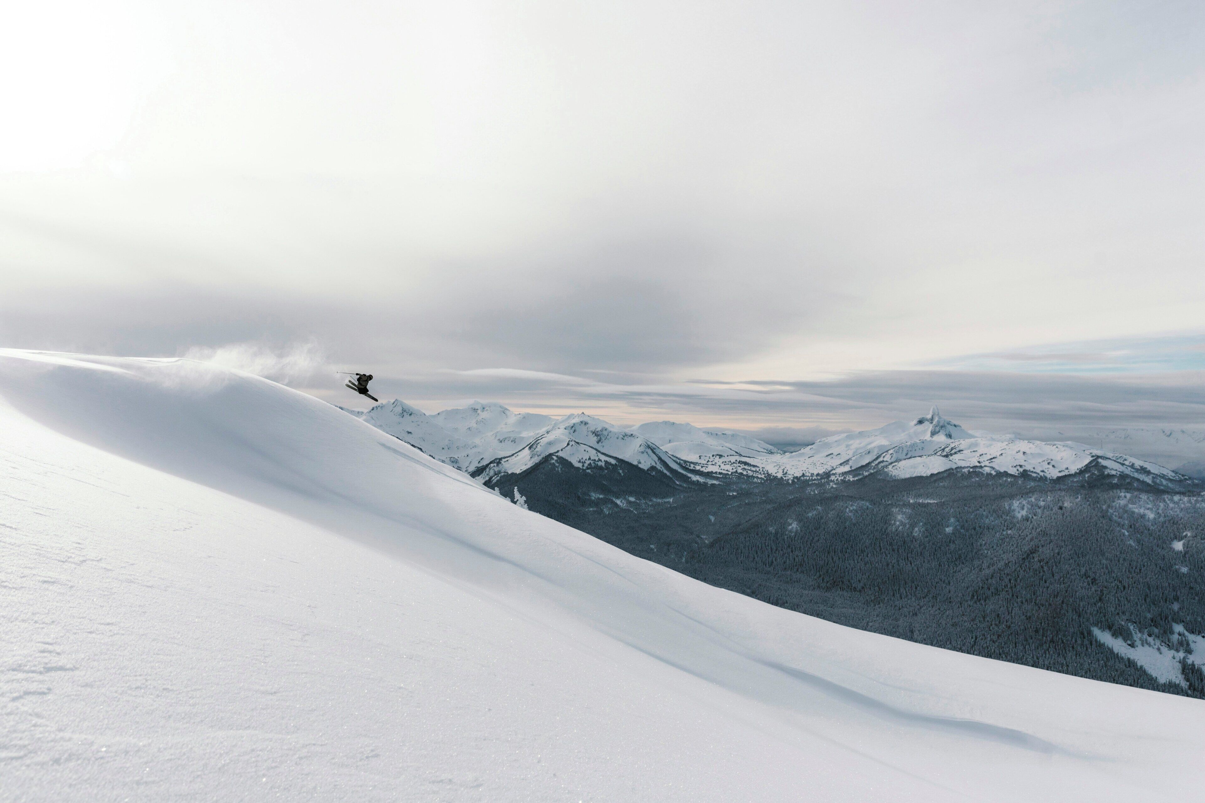 A snowy mountain landscape with a helicopter in flight.
