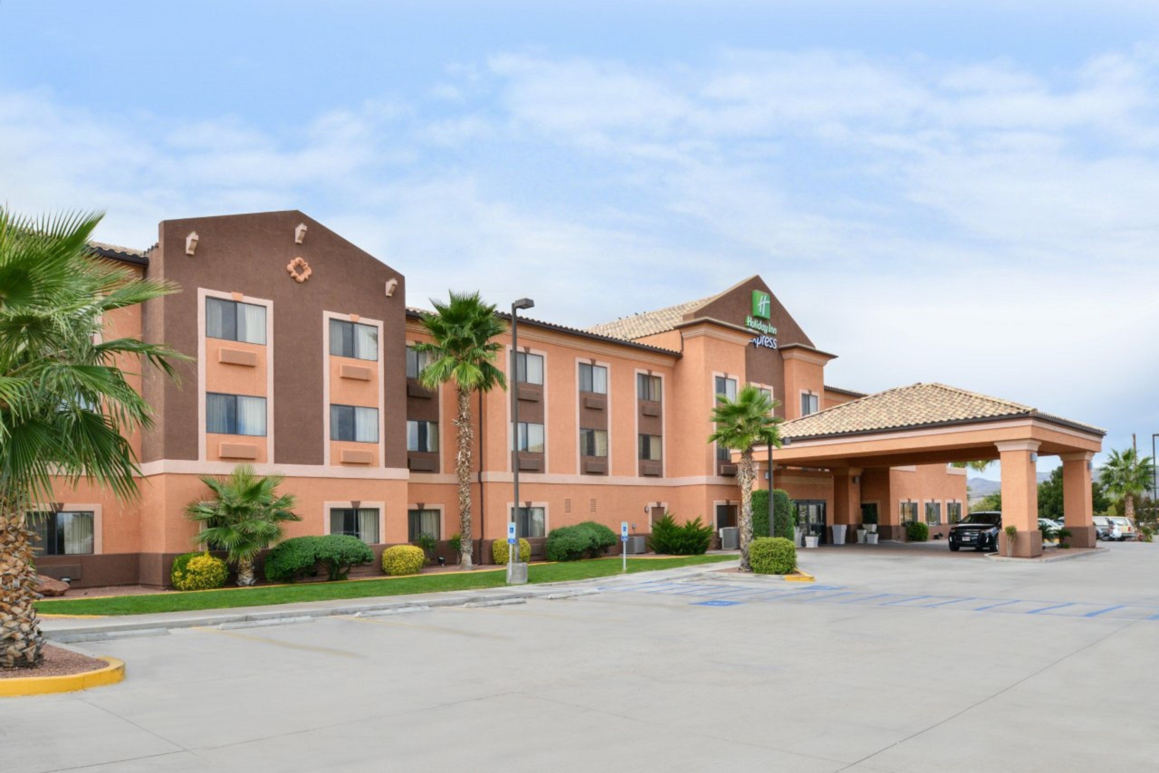 A hotel with a covered entrance, multiple floors, and a parking lot.