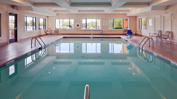 An indoor swimming pool with clear water, surrounded by lounge chairs and a sunroof. - Holiday Inn Express Hotel & Suites Kingman by IHG (Kingman)