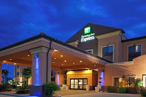 Edificio de Holiday Inn Express con un acceso cubierto, palmeras y una piscina.