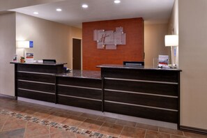 A reception desk with a wooden finish, a tiled floor, and a wall-mounted sign above the desk. - Holiday Inn Express Hotel & Suites Kingman by IHG (Kingman)