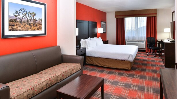 A hotel room with a bed, a sofa, a desk, and a chair. - Holiday Inn Express Hotel & Suites Kingman by IHG (Kingman)