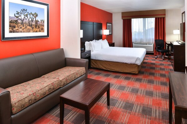 A hotel room with a bed, a sofa, a desk, and a chair. - Holiday Inn Express Hotel & Suites Kingman by IHG (Kingman)