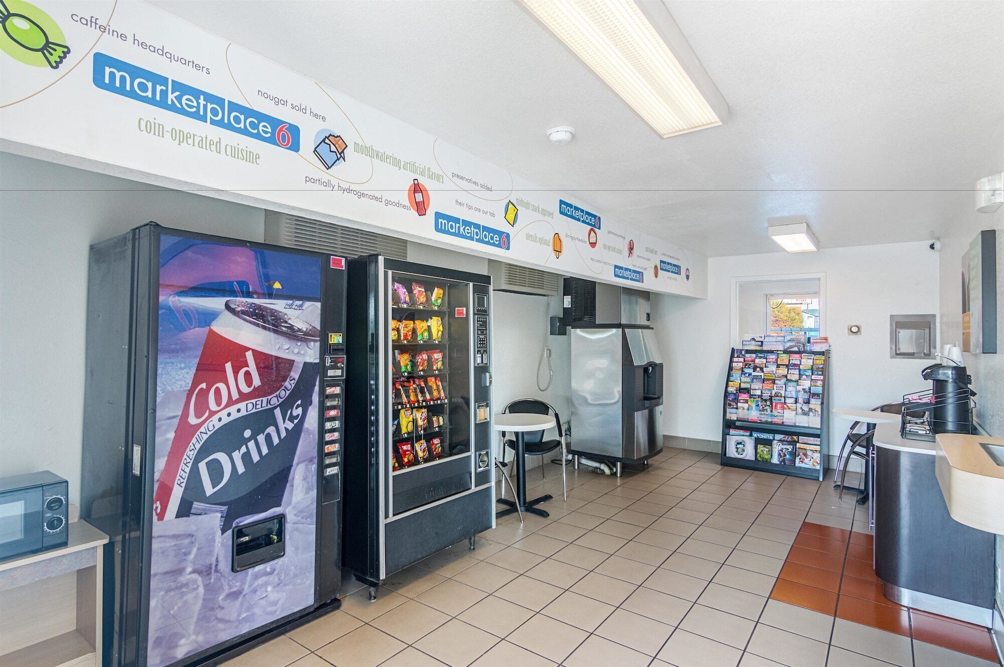 A clean, modern interior with vending machines, a coffee machine, and a small seating area.