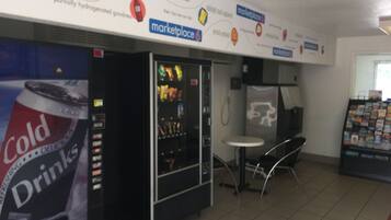 A vending machine area with a 'Cold Drinks' sign, a small table, and a 'marketplace' sign above.
