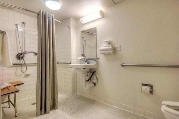 Ein Badezimmer mit Dusche, Toilette, Waschbecken und Handtuchhalter.