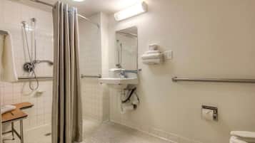 A bathroom with a shower, sink, toilet, and a towel rack.
