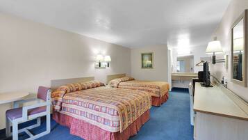 A hotel room with two beds, a desk, a chair, a dresser, and a mirror.