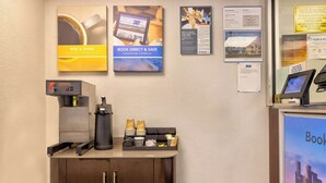 A coffee station with a coffee machine, cups, and a menu board. - Motel 6 Villa Park, IL - Chicago West (Villa Park)