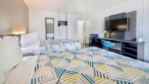 A hotel room with two beds, a TV, a desk, and a chair. - Motel 6 Villa Park, IL - Chicago West (Villa Park)