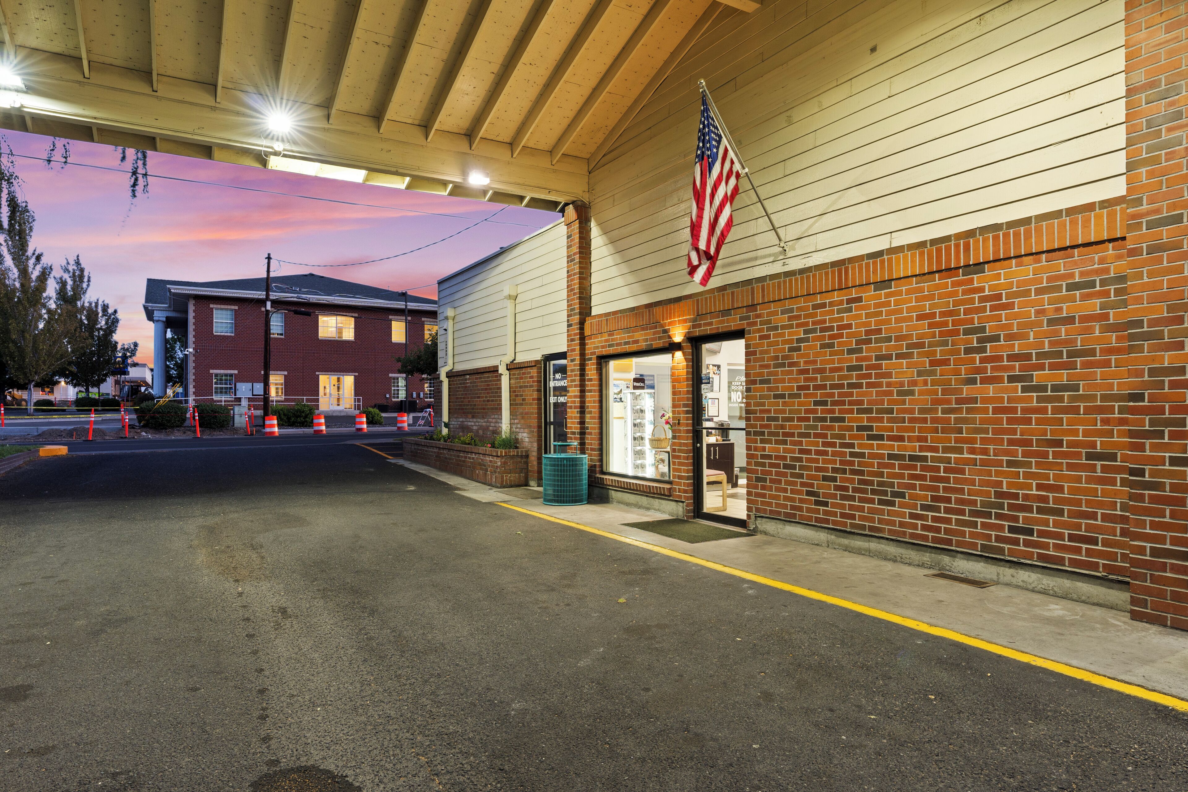 A gas station with a brick facade, an American flag, and a clear sky in the background.
