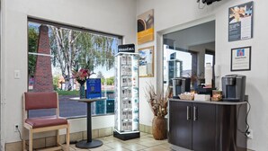 Un espace d’accueil comprenant une chaise, une vitrine, un téléphone pour les visiteurs et une machine à café.