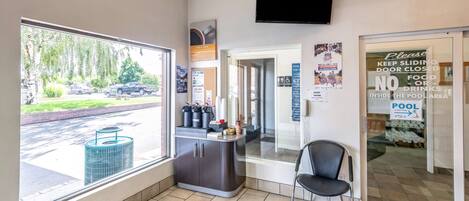 A pool area with a closed door, a chair, and a counter with amenities.