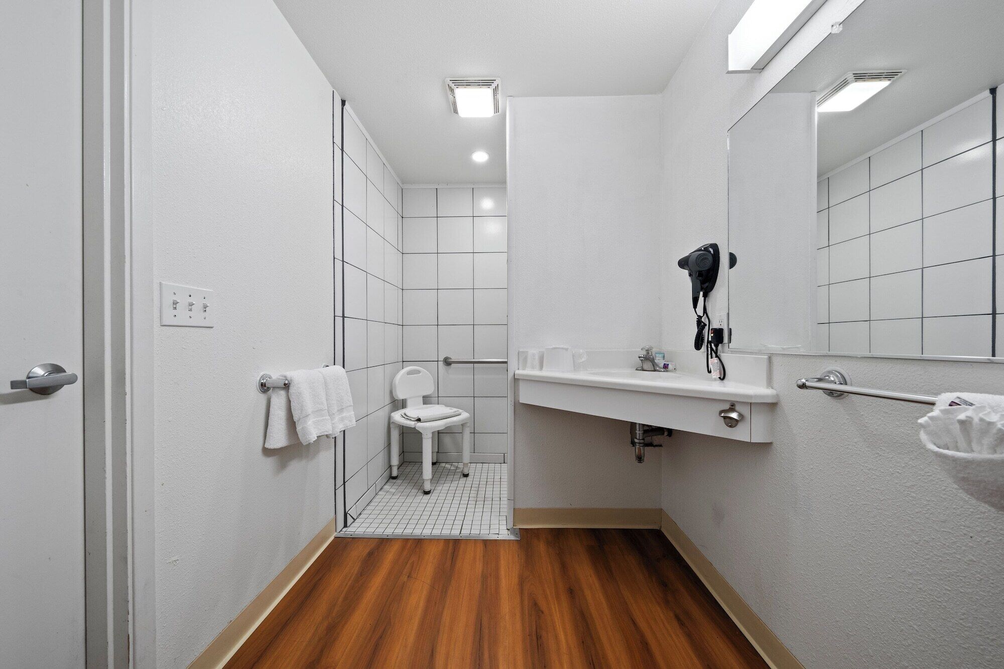 A small, modern bathroom with a toilet, sink, and mirrors.