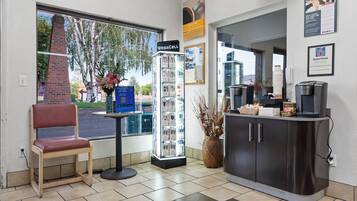A reception area with a chair, a WeGACELL display, a coffee station, and a guest phone.