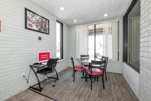 Un centro de negocios con escritorio para computadora, sillas e indicación de Wi-Fi gratuito.