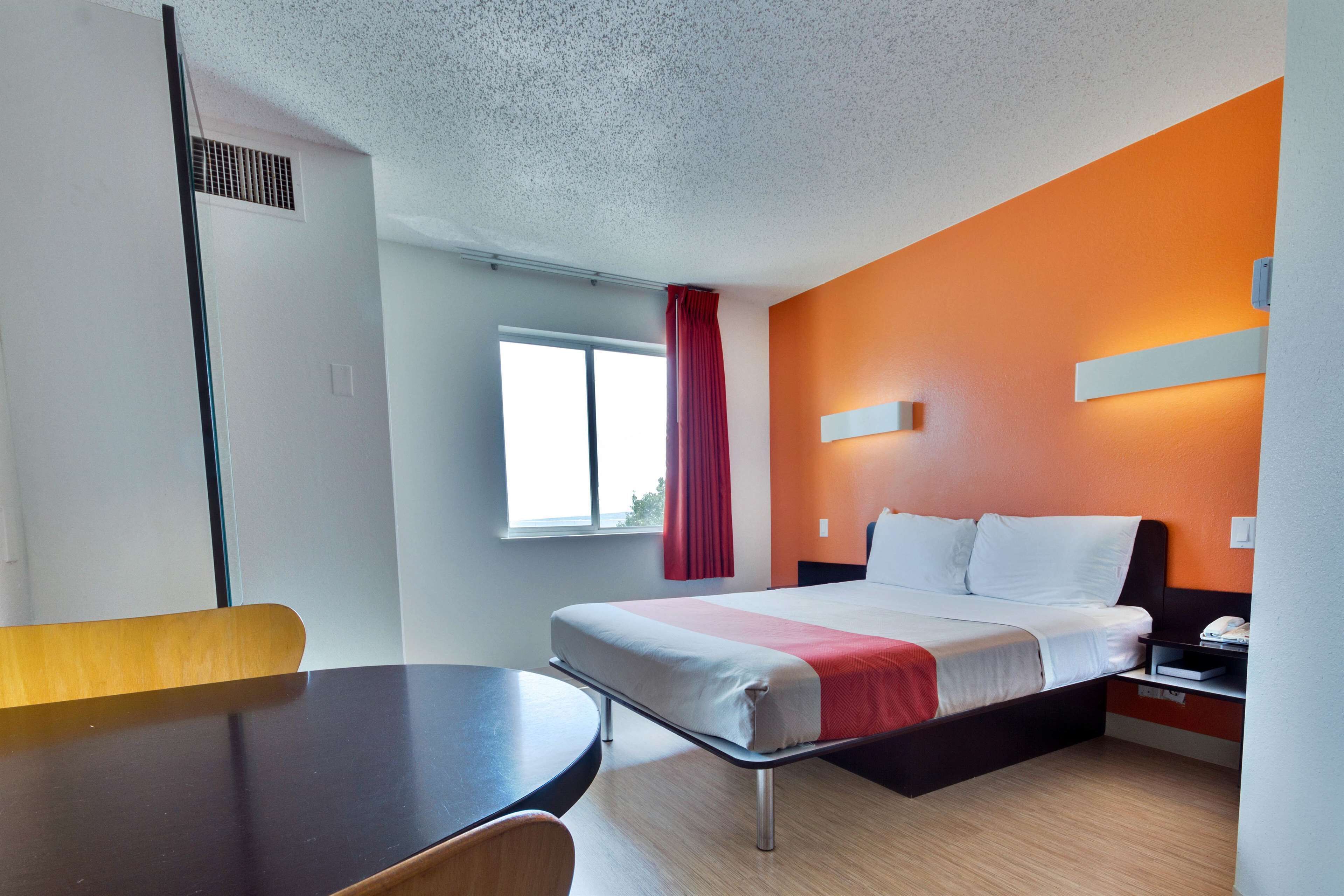 A hotel room with a bed, a desk, and a chair.
