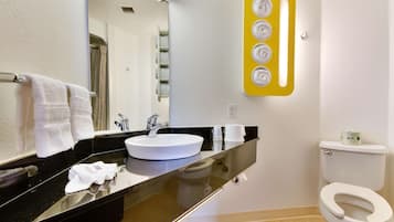A bathroom with a white sink, black countertop, and a toilet.
