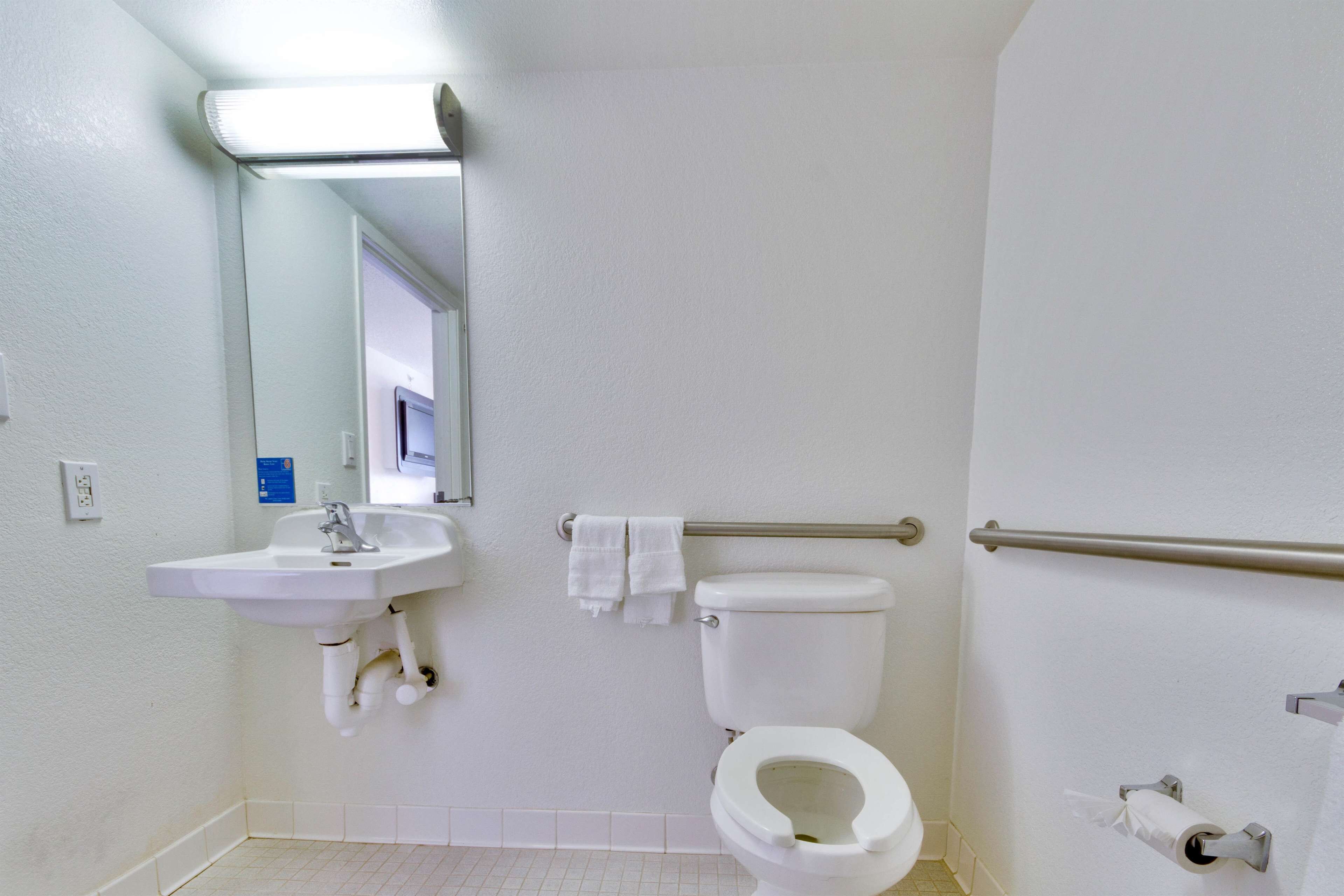 Ein Badezimmer mit Waschbecken, Toilette und Spiegel.