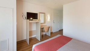 A hotel room with a bed, a desk, a chair, a television, and a wardrobe. - Motel 6 Columbia, SC - Fort Jackson Area (Columbia)