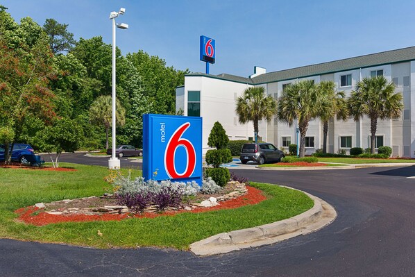 A 6 Motel with a modern building, parking lot, and landscaped area with trees and shrubs. - Motel 6 Columbia, SC - Fort Jackson Area (Columbia)
