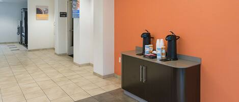 A reception area with a counter, a coffee machine, and a water dispenser.