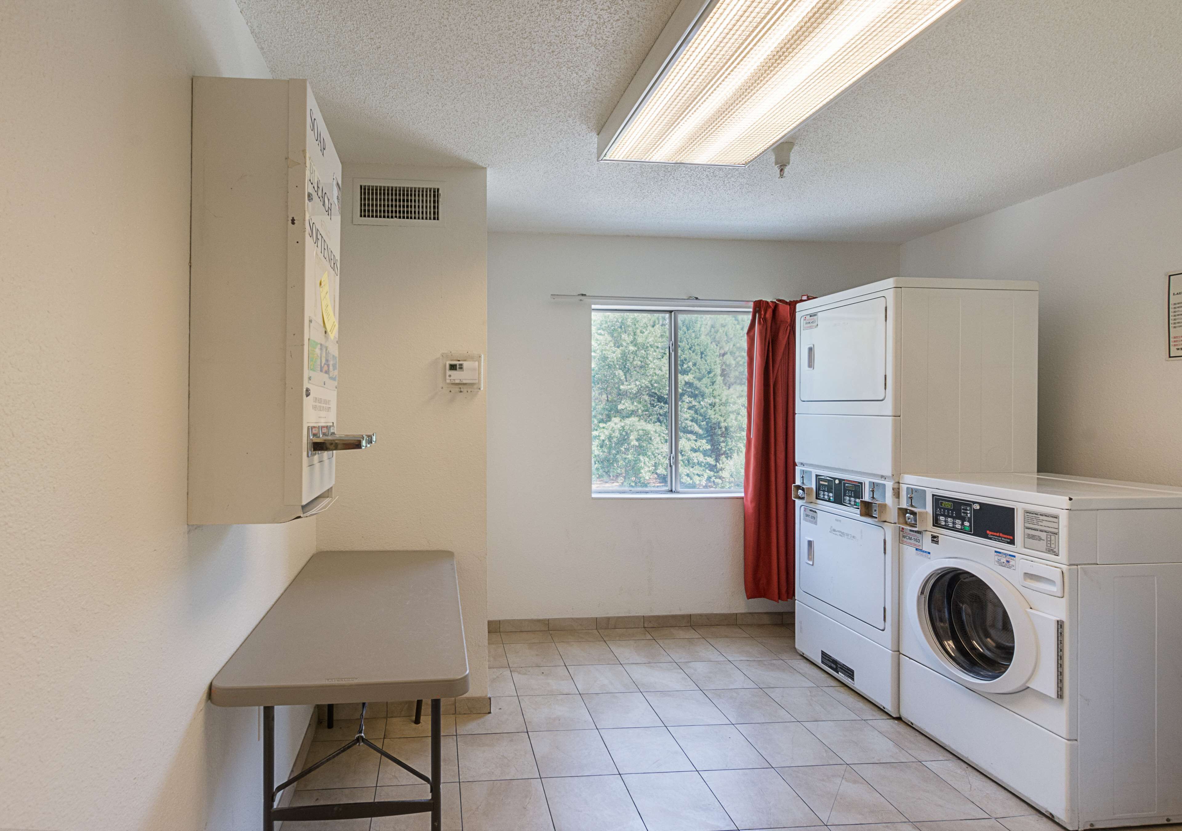 A laundry room with a washing machine, dryer, and a table.
