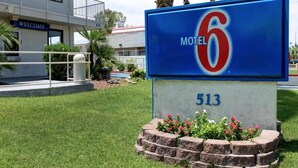 A motel sign with the number 513 and the name 'Motel 6' in front of a building with a balcony and a 'WELCOME' sign. - Motel 6 Tempe, AZ - Broadway - ASU (Tempe)