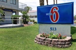 A motel sign with the number 513 and the name 'Motel 6' in front of a building with a balcony and a 'WELCOME' sign. - Motel 6 Tempe, AZ - Broadway - ASU (Tempe)
