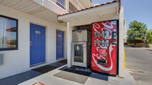 A building with two blue doors, numbered 128 and 129, and a Coca-Cola vending machine. - Motel 6 Tempe, AZ - Broadway - ASU (Tempe)