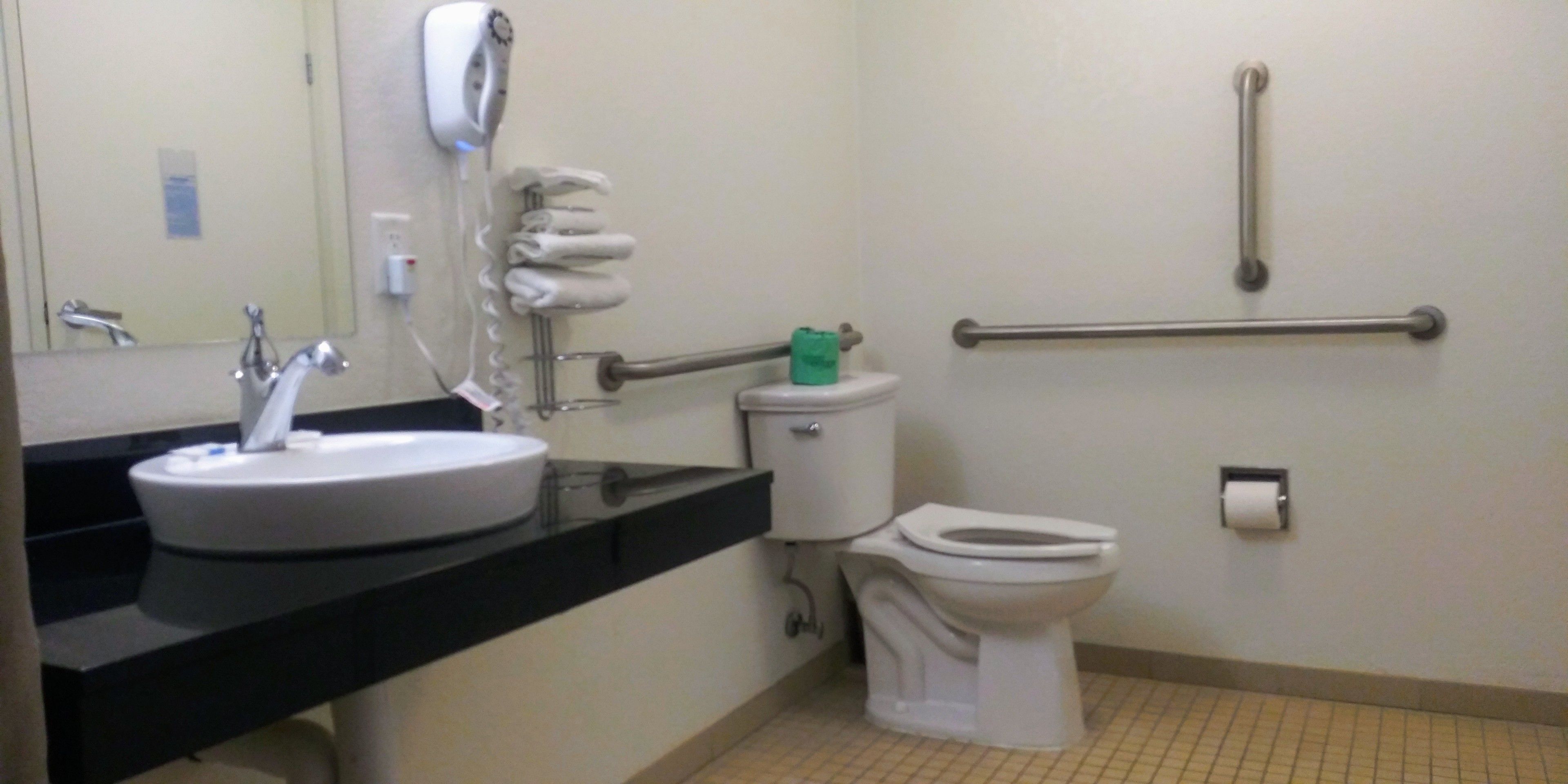 A bathroom with a sink, toilet, and hand dryer.