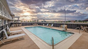 A rooftop pool with lounge chairs and a view of the sunset. - Motel 6 Euless, TX - Dallas (Euless)