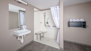 A modern bathroom with a sink, mirror, shower, and towel rack. - Motel 6 Euless, TX - Dallas (Euless)
