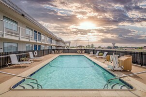 Una piscina al aire libre de temporada, sombrillas