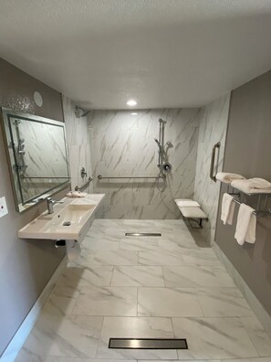 Un bagno moderno con due lavandini, una doccia, una panca e un portascope.