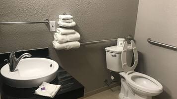 A bathroom with a sink, toilet, and towel rack.