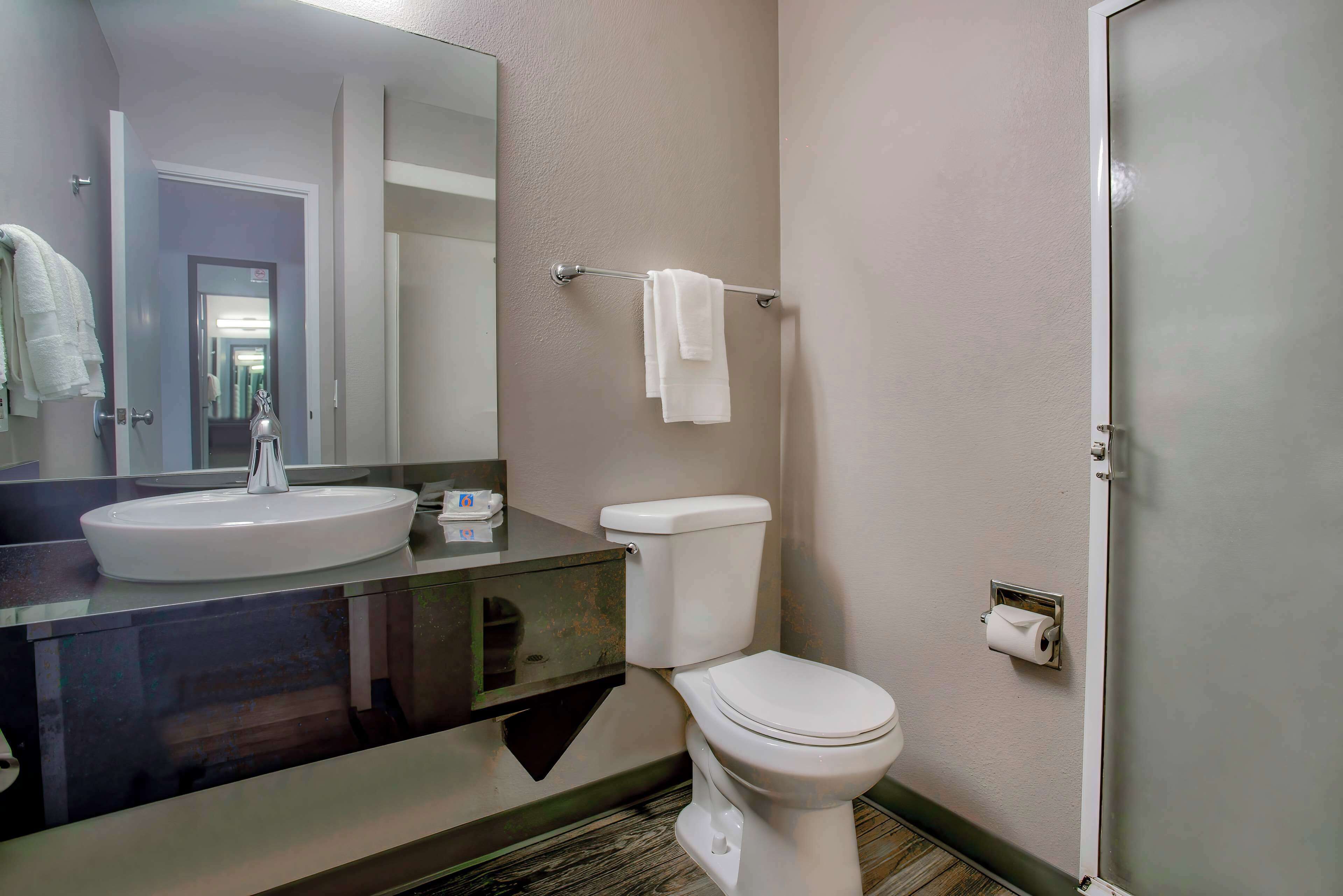 A bathroom with a sink, toilet, and a towel rack.