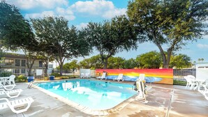 A swimming pool with lounge chairs and a mural wall. - Motel 6 Del Rio, TX (Del Rio)