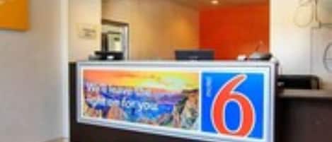Balcão de recepção com tela digital e placa grande com o número 6.