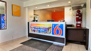 A hotel reception area with a large sign advertising a 6-star rating, a computer, a phone, and a fire extinguisher.