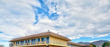 A motel with a two-story structure, multiple rooms, and a parking lot.