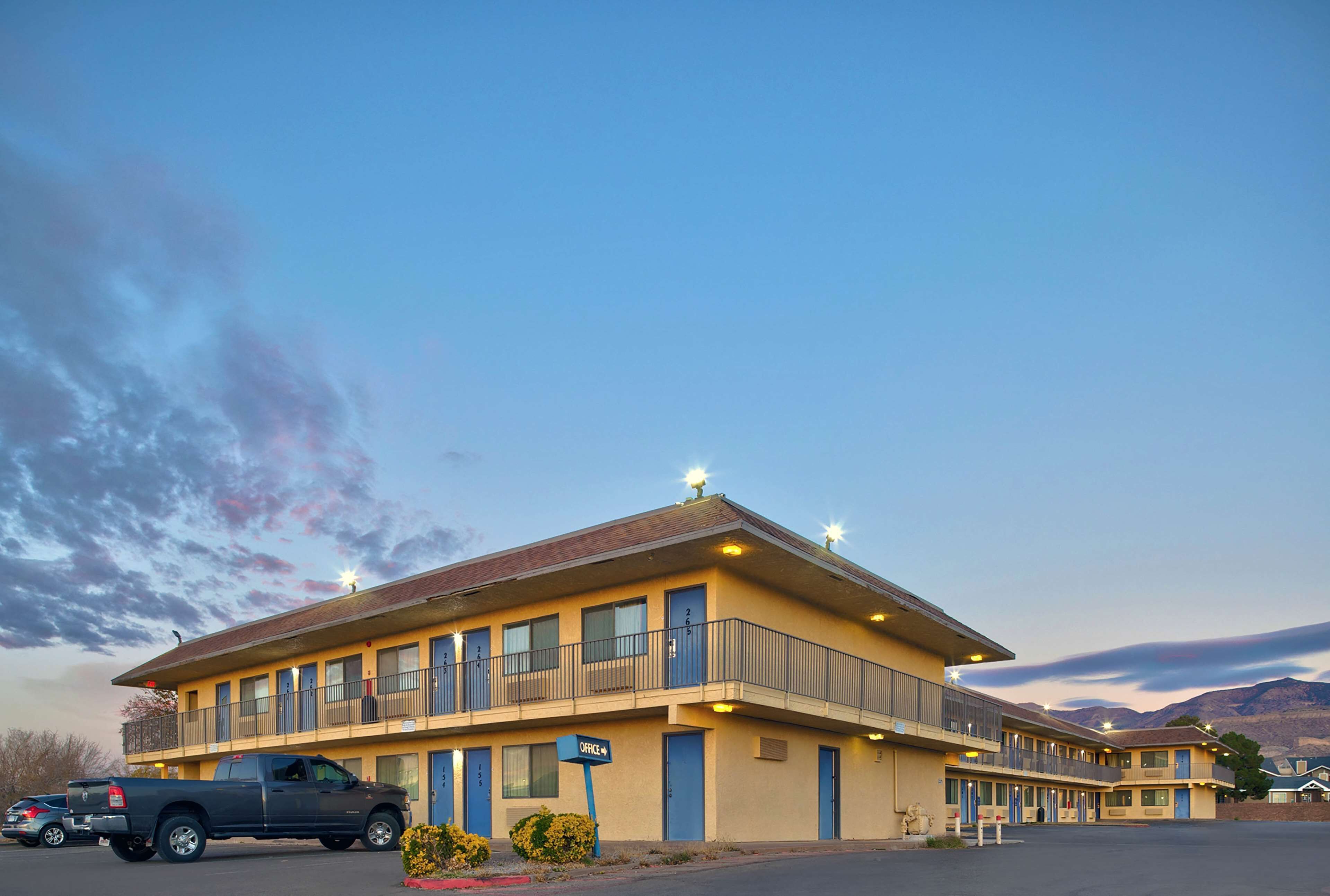 Un motel de dos pisos, con varios balcones y un estacionamiento.