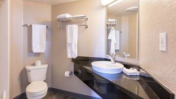 Une salle de bain moderne équipée de toilettes, d’un lavabo et d’un porte-serviettes.