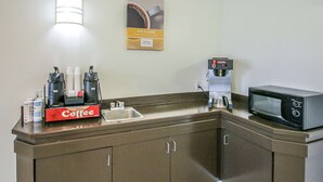 A kitchenette with a coffee maker, microwave, and coffee cups. - Motel 6 Nephi, UT (Nephi)